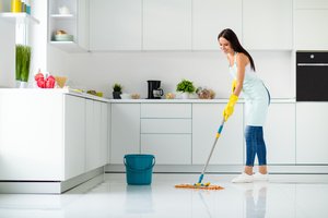 A woman is cleaning the kitchen to prevent spring insects